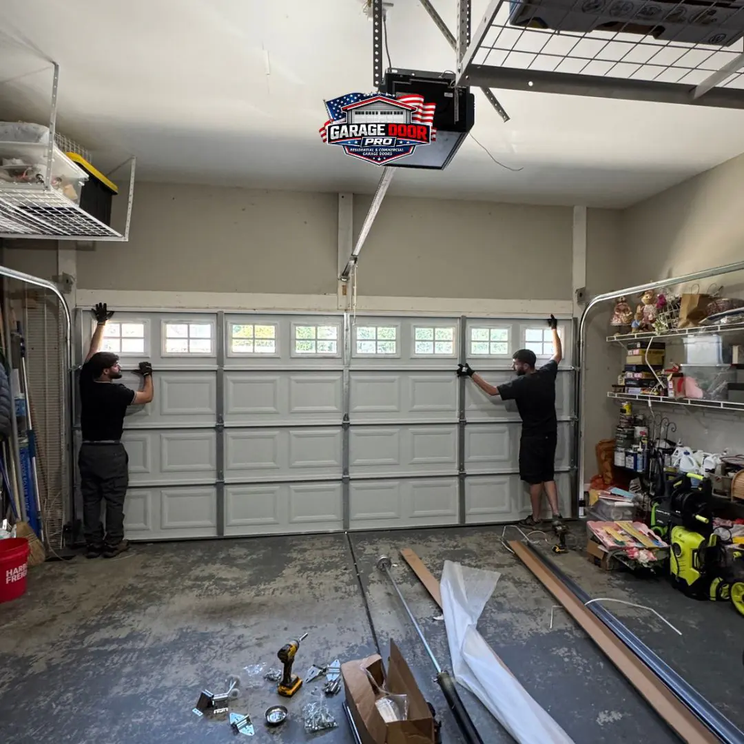 Technicians installing a new garage door from inside the garage